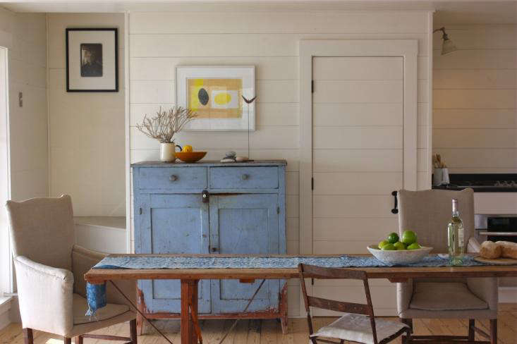 In the dining area of Harbor Cottage, shiplap paneling was used to unify the space and give it an updated cottage feel. Photograph by Justine Hand.